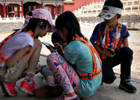 kleine kinderen die met hun telefoon spelen in de Forbidden City in Beijing, China